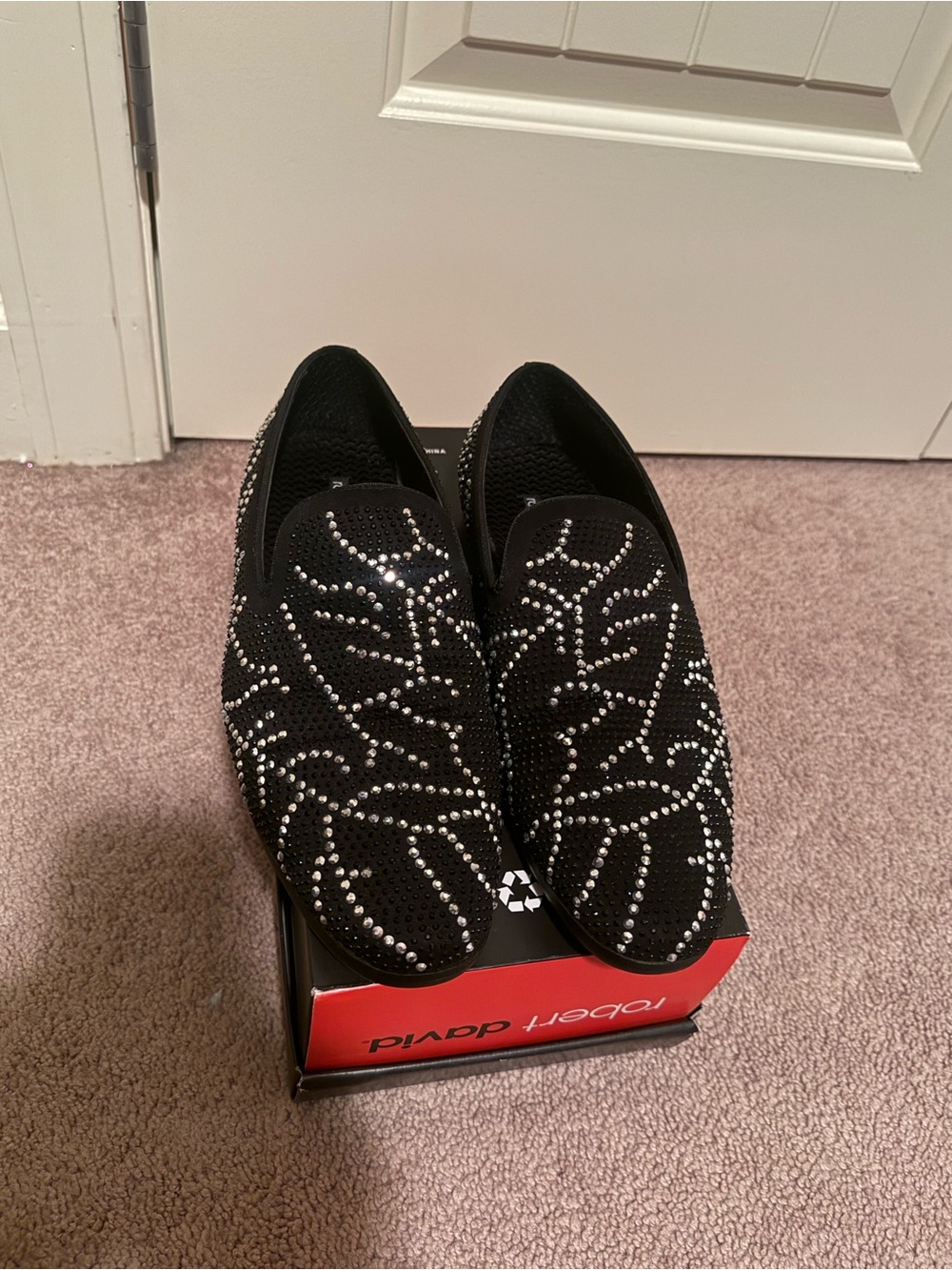 Robert David loafers feature an intricate, leaf-like pattern silver rhinestones